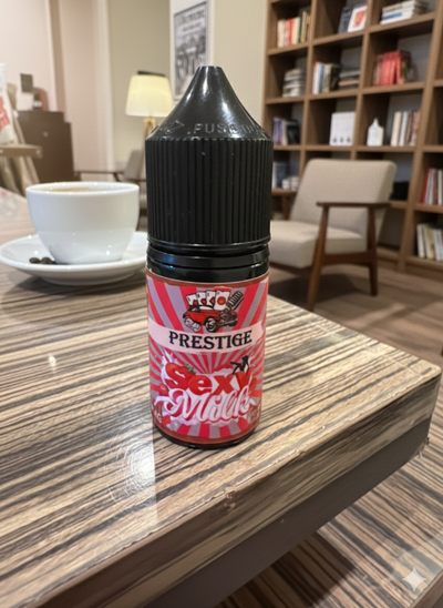 Bottle of Prestige Sexy Swizzle on a table with a cup of coffee and bookshelf in the background