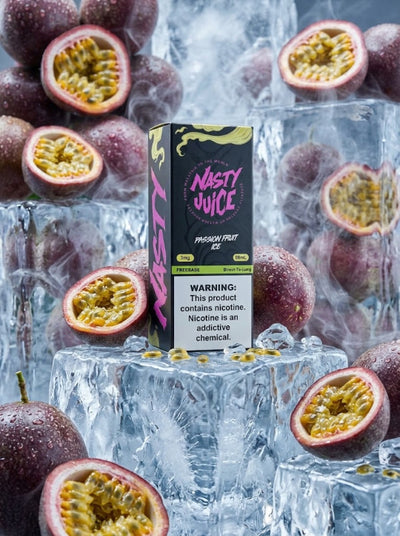 A boxed vape product labeled 'Nasty Juice Passion Fruit Ice' stands upright in a styled arrangement of ice cubes and whole and halved passion fruits. The box is black with bright pink and yellow graphics, and the scene is set against a cool blue-toned background.