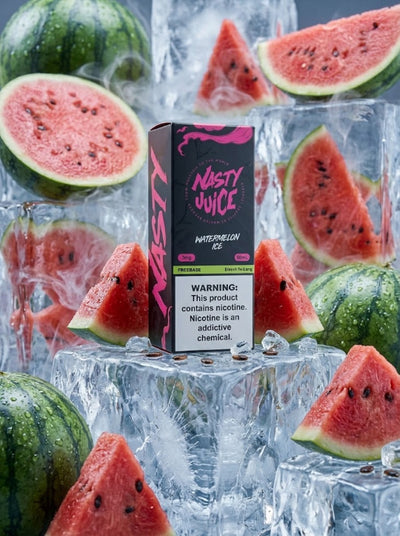 A box of Nasty Juice Watermelon flavor vape oil stands upright on ice cubes, surrounded by sliced watermelon and whole watermelons in a styled studio setup.