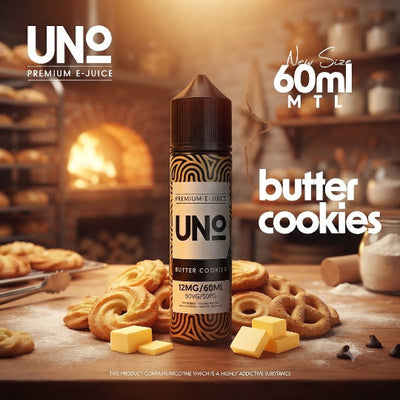 A bottle of UNO Premium E-Juice in the Butter Cookies flavor, displayed on a wooden table surrounded by butter cookies, butter cubes, and baking ingredients, with a warm, blurred bakery background.